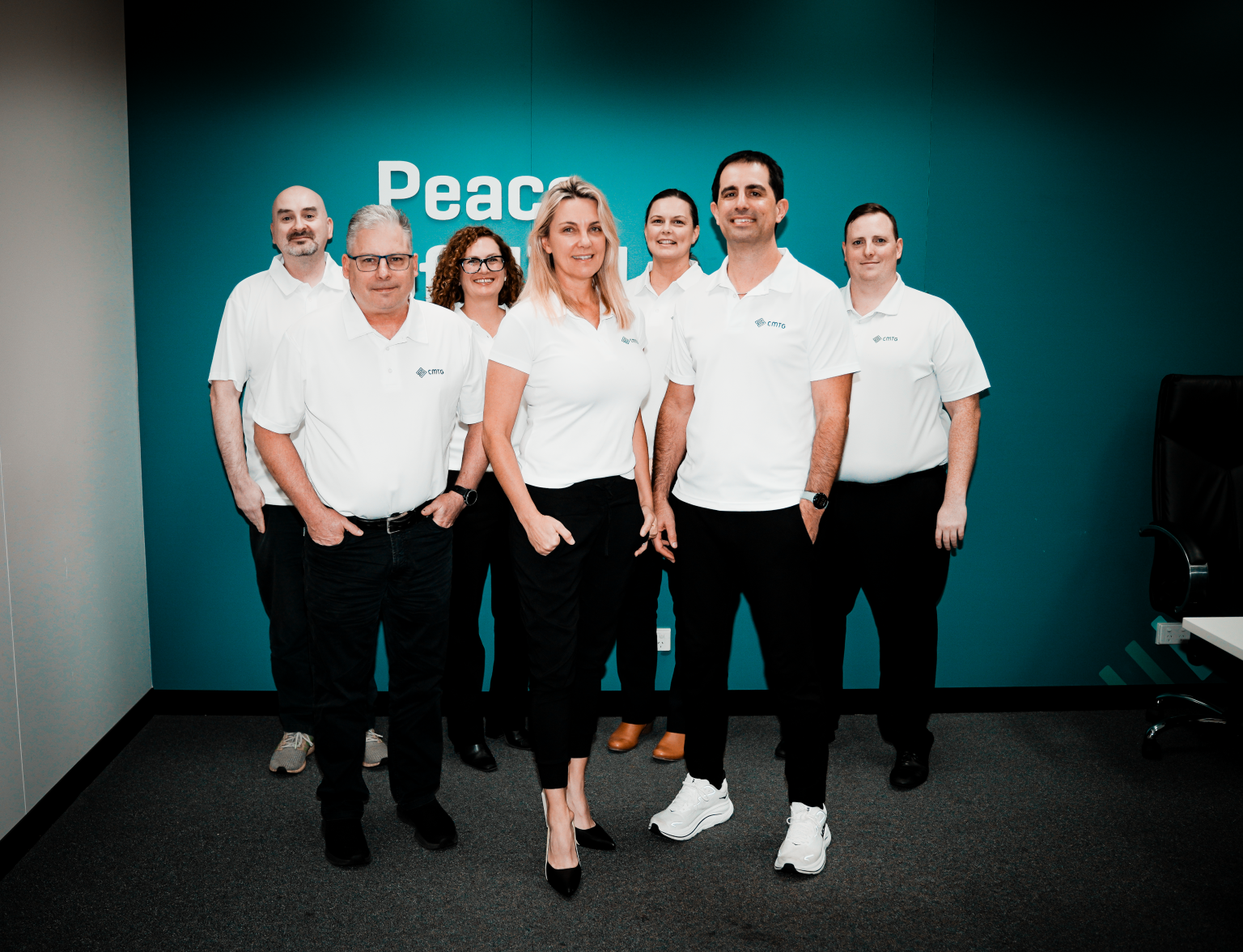 CMTG group in white shirts smiling and posing together for a photo, representing IT support in Perth.